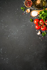 Food background with fresh vegetables, herbs and spices on black.
