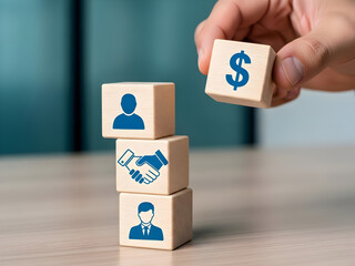 Hands stacking wooden blocks with human and dollar icons representing HR financial management and business resources