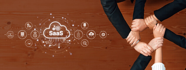 This image depicts a collaborative business partnership with hands joining around a SaaS cloud concept, symbolizing teamwork and innovation in a modern workspace. Trope