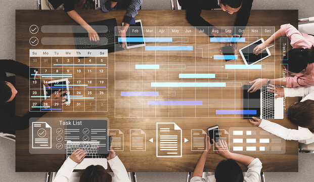 A modern workspace featuring a collaborative team meeting with digital project management tools. Laptops, tablets, and a task list create an organized environment for productivity. Gantry