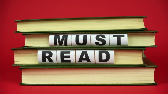 Books come into the frame and appears phrase MUST READ. Red background. Stop motion animation
