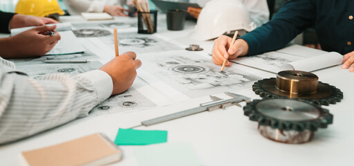 A collaborative group of engineers focused on technical drawings and tools in a modern workspace, promoting creativity and innovative solutions during a planning session. SACTR © InfiniteFlow