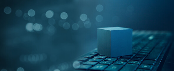 Digital composite of Blue cube with bokeh background and computer keyboard