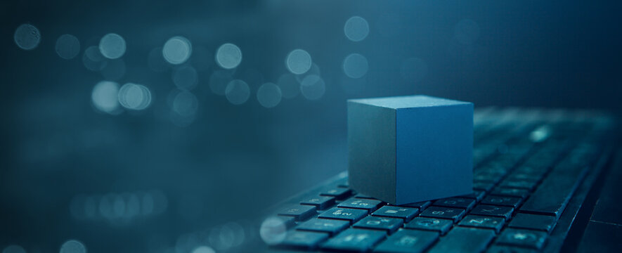 Digital composite of Blue cube with bokeh background and computer keyboard - Powered by Adobe