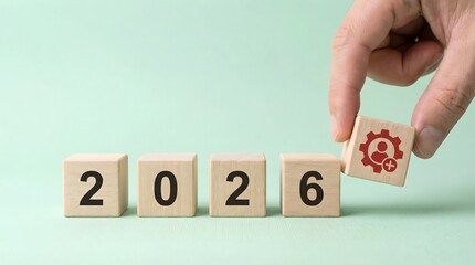 Hand placing block with new year 2026 and user icon, future planning concept