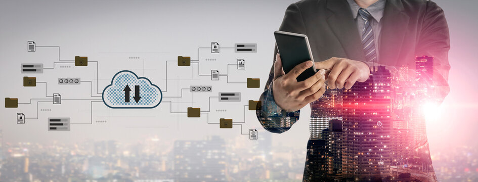 A businessman in a suit uses a smartphone amidst a blend of cloud technology and data flows, symbolizing the integration of communication and innovation in urban settings. Gantry - Powered by Adobe
