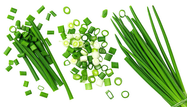 Close-up top view of freshly cut green chives, some whole, others chopped, on black