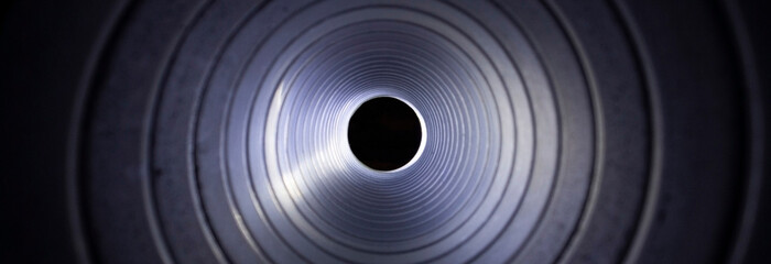 closeup view from inside the galvanized steel air duct on the exhaust fan in the background light, the front and back background is blurred with a bokeh effect