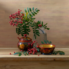 Still life with red rowan berries and wooden utensils painted with Khokhloma style