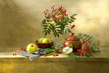 Still life with red rowan berries and wooden utensils painted with Khokhloma style