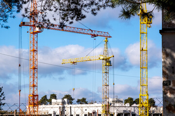 Tower cranes at construction site behind fence
