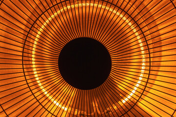 Close-up of circular orange light fixture with radiating lines and dark center
