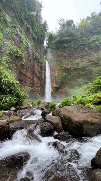Koban Kapas Biru is a waterfall in the tropical jungles of East Java, descending from a high cliff into a lush green canyon surrounded by tropical forests with vibrant vegetation.Lumajang River. 4К