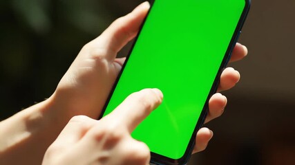 Human hands interacting with a modern smartphone displaying a vibrant green screen for easy content replacement in a versatile Phone Mockup