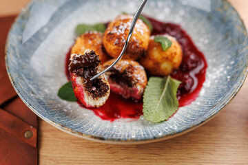 Delicious Ukrainian dessert balls served with berry sauce highlighting rich flavors and textures