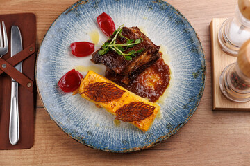 Dishes from diverse cuisines showcased on a plate with intricate presentation featuring meat, sauce, and garnishes