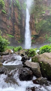 Koban Kapas Biru is a waterfall in the tropical jungles of East Java, descending from a high cliff into a lush green canyon surrounded by tropical forests with vibrant vegetation.Lumajang River. 4К