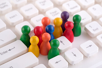 Colorful group of pawn people figures on computer keyboard