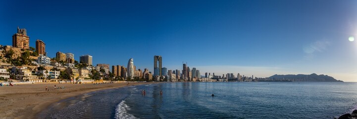 Obraz premium Benidorm skyline and beach with people enjoying the sea.