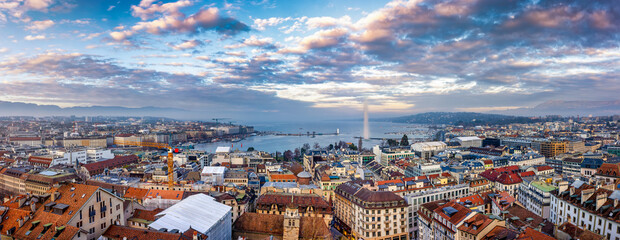 Elevated, panoramic view of the skyline and lake of Geneva, Switzerland, during a winter sunset with fog