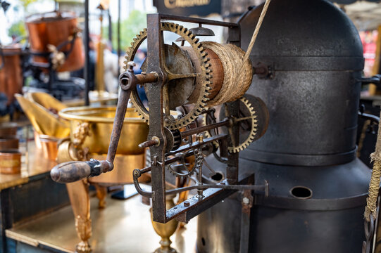 Traditional vintage French equipment for roasting and grilling fresh chestnuts over open fire, delicious street food, eating nuts on streets of Paris in autumn