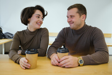 Happy couple enjoying coffee together at a cafe, smiling and sharing a friendly conversation