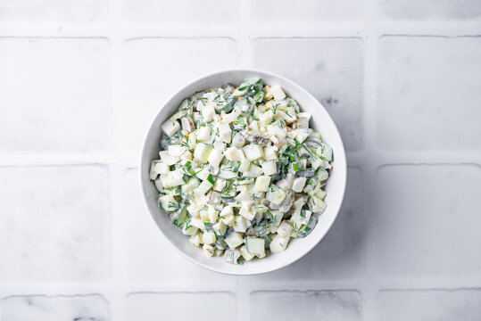 Cucumber egg mayonnaise salad in a bowl on a white background
