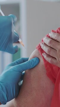 Elderly vaccination scene, Calm healthcare worker giving immunization to elderly person in clinical environment