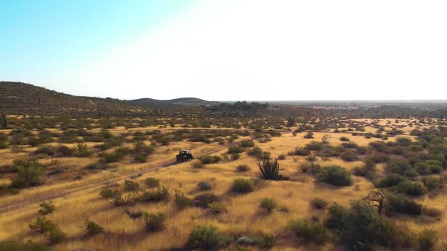 toma aerea de drone de un veh&iacute;culo Ranger 4x4 viajando en medio del desierto de Sonora M&eacute;xico durante una tarde soleada de de verano 