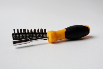 screwdriver handle and a set of screwdriver bits on a white background
