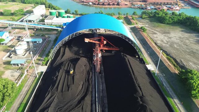 Aerial panoramic image of a very large enclosed coal storage facility with active bulk material.