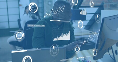 Typing central analyst at desk wearing dark hoodie, using keyboard and viewing HUD on monitors