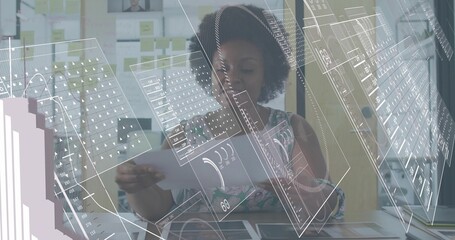 Reading woman in patterned top holding printed layouts at desk, viewing holographic UI overlays