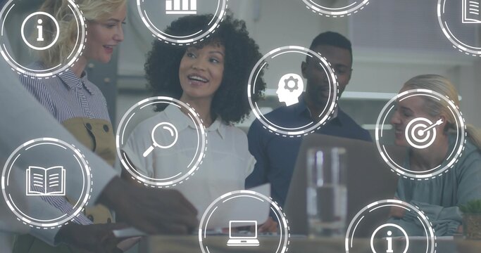 Discussing, team of four in business attire reviewing laptop and papers in office with UI icons - Powered by Adobe