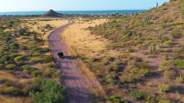 Toma aerea con dron de un ranger cruzando el desierto de Sonora para llegar al mar de bahia de kino