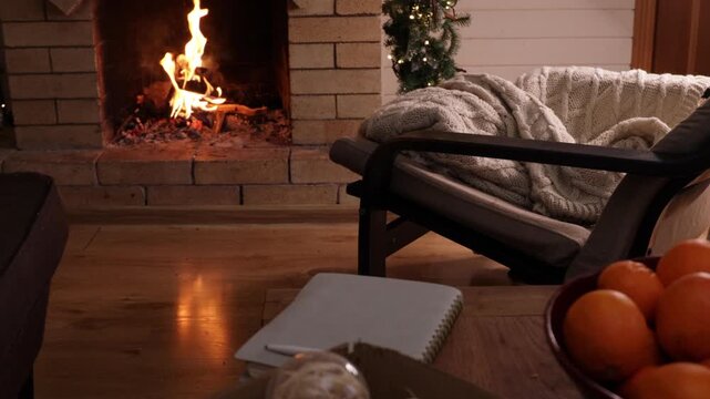View of a cozy and warm living room interior with a burning fireplace. Soft firelight creates a comfortable winter atmosphere, symbolizing home comfort, relaxation, warmth, and peaceful evenings indoo