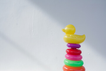 Educational stacking ring toy with large plastic base and multiple brightly colored circular rings designed for toddlers to learn motor skills coordination and color recognition 