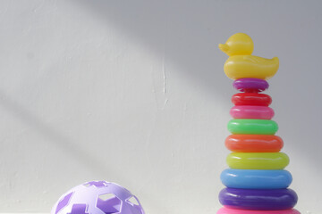 Educational stacking ring toy with large plastic base and multiple brightly colored circular rings designed for toddlers to learn motor skills coordination and color recognition 