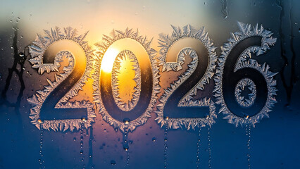 frozen 2026 year number composed of ice crystals and frost patterns on a window pane with golden winter morning sunrise light for new beginnings