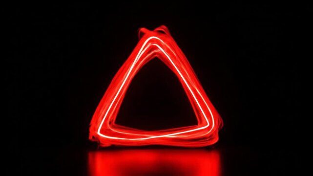 Abstract red triangle light painting on a dark background, creating a futuristic and dynamic effect.