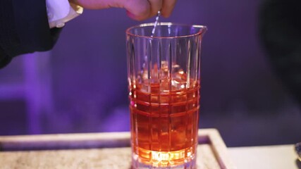 Bartender working, beautiful row line of different coloured liquor alcohol cocktails on a party in a bar, catering banquet on event, barman mixing drinks, selection of beverages in a restaurant club