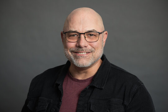 portrait of senior man with glasses, isolated on grey background
