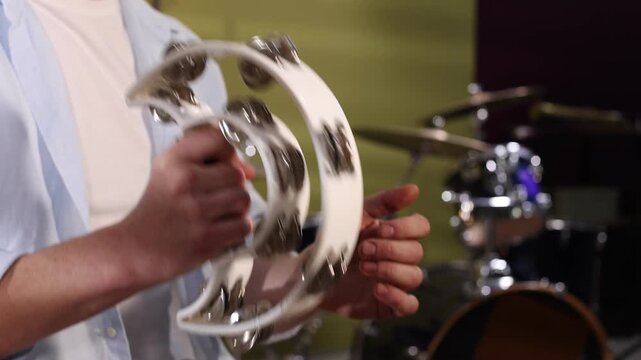 Man playing tambourine in studio, closeup view