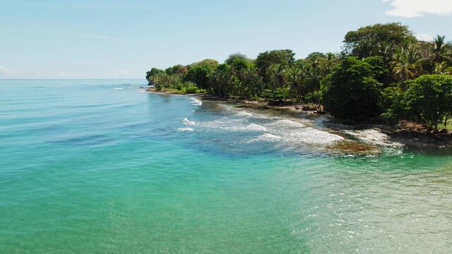Tropical coastline with palm trees and turquoise sea on sunny day at Playa Cocles Puerto Viejo Costa Rica