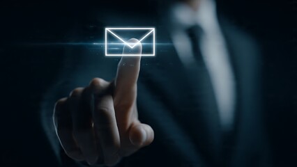 Professional businessman's finger touching glowing email icon on dark digital interface for instant communication and connection