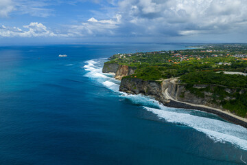 Obraz premium Aerial view of the Uluwatu coastline near Uluwatu Temple showing dramatic cliffs, ocean views, and nearby new construction during warm afternoon light in Bali, Indonesia.