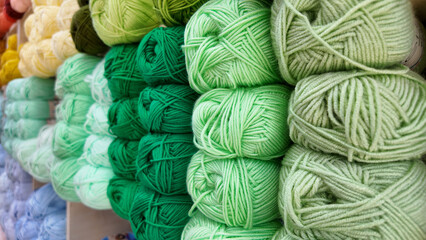 Various shades of green yarn stacked in a craft store