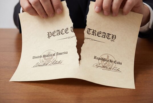 Male hands tearing a formal peace treaty document between the united states and cuba into two pieces
