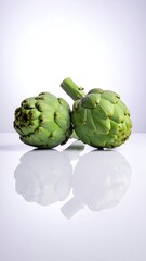 Obraz premium Two artichokes on a white surface