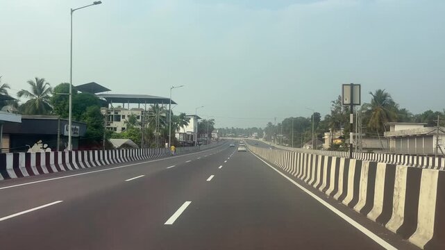Video footage of a newly constructed highway near Kozhikode, Kerala, India, captured in natural daylight. The smooth road surface, fresh lane markings, and modern infrastructure highlight recent devel